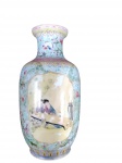 Vaso balaustre em porcelana chinesa decorado  famille rose . Corpo com fundo em tom verde-água trabalhado em volutas, ornado com motivos florais  com cenas orientais. Base com marca em selo vermelho (zhuanshu) apócrifa do período Qianlong.  China, séc. XX. Apresenta desgastes no esmalte e falhas de revestimento na base.  Medidas: 24 cm de altura.