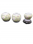 Tres  pequenos vasos em porcelana chinesa decorada em esmalte amarelo com medalhões contendo caracteres caligráficos e motivos florais. Um acompanha base em madeira .Marcas na base em carimbo vermelho com a inscrição "MADE IN CHINA". Segunda metade do séc. XX. Alturas: 10 cm e 13 cm.