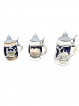 Lote de 3  Canecas de Cerveja Alemãs em Cerâmica e Estanho  decorativas (beer steins) em cerâmica vitrificada em relevo policromado e azul-cobalto, com tampas articuladas em estanho. Motivos de figuras e paisagens alpinas. Medindo 13 cm e 15 cm de altura. Bom  estado de conservação. Marcas na base.
