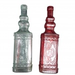 Par de Garrafas Decorativas em Vidro Trabalhado  vintage  relevo geométrico e medalhão central, sendo uma transparente/esverdeada e 1 vermelha. Gargalos moldados com aneis ornamentais. Medida: 30 cm de altura cada. Em bom estado de conservação.