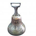 Sino  em bronze fundido de corpo bojudo ornamentado com relevos e pega decorada. Medidas: 19 cm de altura por 13 cm de diâmetro na base. Apresenta pátina escurecida natural e marcas do tempo. Vendida no estado.