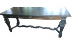MESA DE ESCRITÓRIO ESTILO NEO-RENASCENÇA COM 3 GAVETAS  EM jacarandá maciço, datada da transição do século XIX para o século XX (circa 1900- 1940). Apresenta tampo retangular de grande nobreza e cinta frontal integrada com três gavetas equipadas com puxadores em metal fundidos de inspiração clássica. Sustenta-se sobre quatro pernas robustas, ricamente esculpidas em talha profunda com volutas, folhas de acanto e motivos fitomórficos, unidas por um elegante travessão inferior recortado em curva e contracurva. Medidas: 2,00 x 0,80 x 0,7 m.(Apresenta leves marcas de uso e pátina natural do tempo). Retirada com agendamento na Barra da Tijuca.