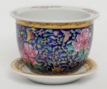 China / Jingdezhen /  Família Rosa. Porcelana de pasta dura, policromia, pintura overglaze em relevo.Cachepot com presentoir. Sobre o fundo esmalte azul, é pintado, peônias com folhagens, borboletas voando entre floras.  Borda superior, 4 ramos de peônias. Borda inferior, uma faixa amarela com ramos e flores. Sousplat com faixa amarela na borda, decorada com moedas antigas chinesas. Marca no verso do sousplat. Excelente estado de conservação.Altura 17 x 23 cm.