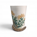 Grande Vaso Cilíndrico em Porcelana estilo Bitong - Porcelana esmaltada com fundo em tom marfim, Rica pintura policromada manual com representação de crisântemos amarelos , folhas em nuances de verde e azul,  Apresenta  assinatura ,selo vermelho na lateral inferior direita , base em madeira , medindo 21 x32 cm