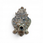 Aplique em bronze fundido no formato de cabeça de leão, com crista ornamental superior em folhas de acanto e abertura circular vazada na boca , apresentando pátina natural do tempo com zinhavre. Peso 528 gr. No estado .Dimensões: 13 x  9 cm