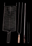 Lote composto por 4 utensílios de churrasqueira em metal com cabo em madeira - sendo 1 grelha dupla dobrável 83x28 cm - 1 espeto duplo 87x07 cm - 1 espeto 85 cm - 1 pegador 40x04 cm - com desgastes do uso e necessitando limpeza.