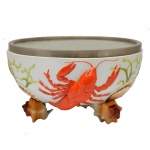 Alemanha. Circa 1900 - Saladeira alemã de estilo Art Nouveau. Formato circular em porcelana com detalhes em relevo destacando-se lagosta, algas e pés moldados em formato de conchas. Borda em metal prateado  da WMF. 12 x 21 cm. Passamos para informar os detalhes e o procedimento para a retirada do seu lote: O lote encontra-se originalmente em Belo Horizonte (MG). e estará disponível em nosso escritório em São Paulo (SP) a partir de uma semana após o término do leilão. A retirada deve ser feita exclusivamente mediante agendamento prévio. Telefone para agendamento: (11) 5044-1228. Por favor, entre em contato conosco pelo telefone acima para escolher o melhor dia e horário para buscar o seu lote.