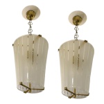 DOMINICI - Par de pendentes de teto vintage no estilo Mid-Century Modern (anos 1950), caracterizados por cúpulas de vidro fosco com listras transparentes e acabamento em latão dourado. Esse modelo de design escandinavo e europeu apresenta uma estrutura de fixação central e correntes delicadas que sustentam a peça. Passamos para informar os detalhes e o procedimento para a retirada do seu lote: O lote encontra-se originalmente em Belo Horizonte (MG). e estará disponível em nosso escritório em São Paulo (SP) a partir de uma semana após o término do leilão. A retirada deve ser feita exclusivamente mediante agendamento prévio. Telefone para agendamento: (11) 5044-1228. Por favor, entre em contato conosco pelo telefone acima para escolher o melhor dia e horário para buscar o seu lote.