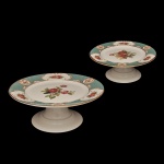 Conjunto de duas doceiras de pé alto em cerâmica da linha Singapura Turquesa da Alleanza. Apresenta decoração com estampa floral e bordas em tom turquesa.
