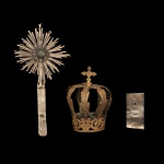 Séc. XIX - Conjunto de 3 objetos sacros em metal prateado , sendo um resplendor circular raiado, centralizando cabochão em pedra verde e haste reta, uma coroa dourada encimada por cruz, e uma placa retangular gravada com as iniciais J.N.R.J. (JESUS DE NAZARÉ REI DOS JUDEUS).  20 x 10 cm (resplendor) / 10 x 6 cm (coroa) e  7 x 3 cm (placa).