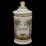 Pote de farmácia em porcelana francesa. Apresenta decoração policromada com motivos de palmeiras e detalhes em frisos de ouro. Rotulo central indica o conteúdo como "AXUNGIA", um termo latino para gordura animal, comumente usados em farmácias antigas. 27 x 12 cm.