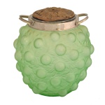 Bomboniere em vidro satinê verde. Apresenta um padrão em relevo de folhas e frutos. Tampa de metal. 17 x 16 cm.