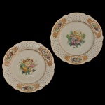 CHARLES PILLIVUYT & CIE. Paris - Par de pratos em porcelana francesa caracterizado por sua rica decoração floral central em policromia e bordas fenestrada adornadas com detalhes em dourado e medalhões florais. Peças com design refinado. Marca da manufatura no verso. 23 cm.