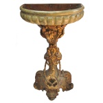 Pia batismal de igreja em madeira com acabamento em ouro velho e entalhes ornamentados de volutas e folhagens. Coluna entalhada terminada profusamente lavrada e ornamentada por volutas e guirlandas realçadas em dourado. acompanhando o estilo. Base com 3 pés altos, acompanhando o estilo. Pode ser usado também como uma bela floreira com pedestal.102 x 65 x 40 cm.