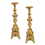 Imponente par de tocheiros em madeira esculpida em estilo neoclássico, realçados por elementos dourados. Elegante ornamentação com frisos, volutas e florões. Hastes montadas com segmentos de balaústre e anelados superpostos, encimadas por bobeches circulares e salientes. Bases ornadas por largas reservas florais, apoiadas em pés revirados sobre peanhas quadrangulares, de mesmo estilo, sustentadas por suportes recortados. Peças Atribuídas ao Mestre Valentin. 82 x 20 x 20 cm (MT). 76 x 16 x 16 cm (sem a base).