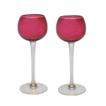 Par de elegantes cálices altos, com bojos ballon de cor vermelho cereja e bordas com filetes a ouro. Hastes compridas, retas e lisas, rematadas por anelados sobre pés circulares. 19 cm.