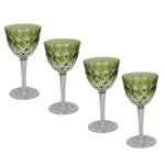 Conjunto de 4 taças em cristal da Boêmia, com bojos cônicos de cor verde musgo, lapidados e ornamentados por treliças realçadas por bolotas raiadas. Hastes retas e facetadas, apoiadas em pés lavrados e ornados com estrelas.14 cm.
