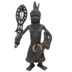 Rara escultura africana em bronze, representando guerreiro com trajes realçados na cintura por presa possivelmente de javali. Região do Benin, Nigéria. Peça de coleção, realçada pela realista expressão e a fineza dos traços do rosto. 76 x 35 x 20 cm.