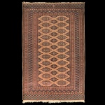 Tapete Oriental com decoração Boukara medindo 192 x 123 cm. Apresenta tons terrosos, adornado com um padrão geométrico repetitivo de medalhões. Sinais de uso e marcas do tempo.