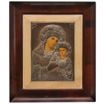 Séc. XIX - ícone religioso russo representando a Virgem Maria (Theotokos) com o Menino Jesus no colo.  26 x 19 cm (MI). 45 x 39 cm (ME). O ícone apresenta faces pintadas de forma detalhada, enquanto as vestes, as auréolas e o fundo são cobertos por uma riza (ou oklad) metálica trabalhada com relevos e gravações ornamentadas (geralmente feita de metal espessurado a prata. A peça central em metal e pintura está fixada sobre uma base revestida em tecido claro, emoldurada por uma robusta estrutura de madeira escura polida com acabamento clássico.