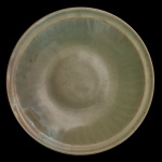 CHINA. Final da Dinastia Ming. Séc. XVII - Medalhão circular em porcelana chinesa, revestido por coberta celadon de cor verde. Apresenta decoração moldada com gomos e borda revirada em debrum. Fornos de Longquan. Final da dinastia Ming, séc. XVII. APRESENTA RESTAURO. 7 x 34 cm.