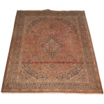 Tapete persa estilo Kashan, apresentando um intrincado padrão floral com um medalhão central em tons de rosa e azul. Medindo 407 x 292 cm, Necessita de lavagem e marcas de uso.