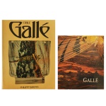 Lote de duas publicações de referência dedicadas ao renomado artista do movimento Art Nouveau, Émile Galle, sendo: A) Trata-se da monografia "Émile Gallé", escrita pelo especialista Philippe Garner. A capa amarela destaca o nome estilizado do artista e exibe um de seus icônicos vasos de vidro decorativo com detalhes de insetos. B) Catálogo oficial da célebre exposição "Gallé", realizada no Musée du Luxembourg em Paris entre 1985 e 1986. A capa apresenta uma arte em tons terrosos que remete às texturas e reflexos característicos dos vidros e vasos criados por Gallé.