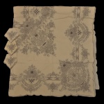 Toalha de linho creme com bordado acinzentado (252 x 164 cm) e 12 guardanapos (41 x 41 cm).