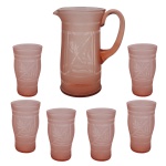 Década de 30  Conjunto de peças para refresco vintage em vidro na cor rosé, decorado com detalhes trabalhados em relevo na superfície. Composto por 7 peças, sendo: Jarra central com alça robusta e bico direcionador (23 x 18 cm) e 6 copos (14 cm).