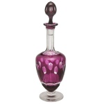 Elegante licoreiro em cristal lapidado em tom magenta, com tampa redonda e corpo abaulado decorado com facetas ovais, conhecidas popularmente como "dedão". 26 cm.