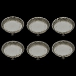 Conjunto com 6 pequenas salvas circulares em prata de lei brasileira, com borda trabalhada em galeria vazada e apoiadas sobre pequenos pés. 9 cm. Peso 554 gramas.