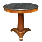 Mesa de apresentação em madeira nobre, estilo Império, com tampo circular saliente em mármore rajado preto. Saia lisa acompanhando o formato. Coluna central reta e levemente afunilada, apoiada em anelado realçado por treliça. Base triangular com pés revirados em volutas. Mármore com mancha e trincado. 76 x 80 cm.