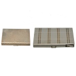 Lote em metal prateado constando de 2 peças, sendo: A) Um poudriere  (porta pó compacto) de maquiagem apresentando uma tampa com textura geométrica quadriculada em relevo. (8 x 7 cm). B) Uma cigarrilha ou porta-cigarros de metal com isqueiro acoplado, decorada com linhas verticais em relevo e equipada com um fecho de encaixe lateral na parte inferior direita. (12 x 8 cm). Espólio de Josephina Penteado da Fonseca, SP.