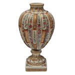 SAMSON - Vaso em porcelana francesa policromada, moldada com gomos verticais, ornamentados com faixas florais intercaladas por estilizações fitomórficas. Bojo cônico, encimado por pequeno gargalo levemente revirado. Haste no formato de carretel anelado, apoiado em base quadrangular, acompanhando a decoração e bordado por friso com argolas. Sob a base, marca da manufatura Samson. Possivelmente séc. XIX. Sem tampa. 30 x 14 cm. Espólio de Josephina Penteado da Fonseca, SP.