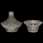 Conjunto de duas peças em cristal translúcidos com lapidação geométrica profunda e complexa, com padrões tradicionais como estrelas (hobstars), diamantes e detalhes serrilhados nas bordas, projetados para maximizar o brilho e o reflexo da luz através do cristal de alta qualidade. Sendo: 1 cesta com alça de formato oval (24 x 25 x 17 cm) e 1 centro de mesa redondo (12 x 23 cm). Espólio de Josephina Penteado da Fonseca, SP.