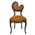 Original cadeira em madeira nobre, estilo Fin de siècle, com influência Art Nouveau. Apresenta encosto assimétrico semicircular, encimado por volutas, com um lado mais alto ornado por treliça vazada. Assento alto no formato de escudo, apoiado em saia ondulada. Pernas curvilíneas, realçadas por joelhos ornados por folhagens e rematadas por pés revirados sobre sapatas. Estofamento em veludo amarelo mostarda. Transição séc. XIX - séc. XX. 92 x 47 x 34 cm. Espólio de Josephina Penteado da Fonseca, SP.