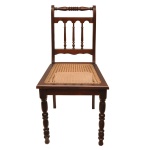 Original cadeira em madeira escurecida, estilo eclético. Encosto com laterais retas, reunidas por cachaço horizontal anelado. Tabela ornada por balaústre com 3 colunatas. Assento em palhinha da Índia, apoiado em saia lisa. Pernas dianteiras retilíneas e torneadas. Transição séc. XIX - séc. XX. 91 x 45 x 42 cm. Espólio de Josephina Penteado da Fonseca, SP.