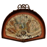 Antigo leque decorado em policromia, representando jovem mulher com putti à sua volta, ladeada por dançarina e anjinhos, sobre fundo ornado por adornos florais, estilizações e volutas. Apresenta base lavrada em madrepérola. Moldura com vidro à frente, acompanhando o formato, em madeira dourada esculpida em torsade e encimada por laço de fita. 32 x 36 x 5 cm. Espólio de Josephina Penteado da Fonseca, SP.