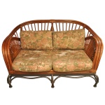 Charmoso sofá namoradeira vintage de vime e bambu, caracterizado por sua estrutura curvilínea em fibra natural e almofadas com estampa tropical. Pés em ferro. Estofado rasgado. NO ESTADO. 83 x 150 x 104 cm. Espólio de Josephina Penteado da Fonseca, SP