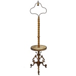 Original luminária de chão em bronze dourado, construída com coluna central espiralada. Apresenta plateau circular à meia altura. Base ladeada por folhagens, rematada por pés recurvos. Parte superior com suporte triangular para cúpula, encimado por bocal para lâmpada e ponteira ao topo. 178 x 40 x 40 cm (MT)