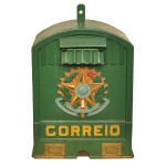 Antiga caixa de Correio em madeira e metal de formato retangular, de cor verde, com parte superior arqueada. Apresenta à frente brasão de armas dos Estados Unidos do Brazil, com estrela de 5 pontas, ladeada por ramos de café e tabaco, e data da Proclamação da República de 15 de Novembro de 1889. Fundo com trave para abertura da caixa. Com chave funcionando. 65 x 40 x 26 cm.