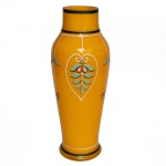 Vaso em vidro opalinado de cor amarelo gema, de formato balaústre. Bojo abaulado, ornado por filete sustentando folhagens estilizadas. Gargalo reto e curto. Base com degrau saliente. 23 x 9 cm.