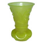 Vaso em vidro moldado de cor verde lima. Bojo cônico realçado por adornos florais em relevo. Base circular, achatada e saliente ornada por meia luas.17 x 12 cm.