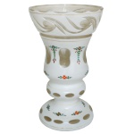 Vaso em cristal europeu, decorado por pequenas flores policromadas. Apresenta overlay leitoso, facetado e ornado por janelas e adornos transparentes. Bojo abaulado, moldado no formato de cone, apoiado em segmento anelado sobre base semicircular. Parte superior revirada e ornamentada por estilizações polidas. 20 x 13 cm.