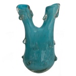 Original vaso de formato reto, com influência naturalística, em cristal monocromático de cor turquesa. Bojo ovalado e alto, encimado por 2 floreiras alongadas. Apresenta decoração em alto relevo com pequenas bolotas transparentes. Base arredondada e retraída. 27 x 17 x 13 cm.