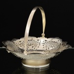 METAL PRATEADO, uma (1) pequena fruteira de pé baixo, borda recortada e vazada em pérgulas, volutas e elementos vegetalistas, marca RÉGIA 90, medindo 16,5 cm diâmetro e 14 cm altura até a alça, vide foto.