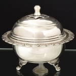 METAL PRATEADO, um (1) antigo pote com tampa, borda relevada em elementos vegetalistas, pés em garra, pega da tampa com terminação em flor, sem marca de manufatura aparente, medindo 12,5 cm altura e 15 cm diâmetro, vide foto.