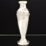 METAL PRATEADO, um (1) vaso floreiro de pé baixo, formato de balaustre, ornado com faixa relevada em rosas, sinais de que já teve alças, marca ORION, base com enchimento, medindo 21,5 cm altura, vide foto.