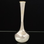 METAL PRATEADO, um (1) vaso solifleur, base em bulbo com mossas, fuste com terminação em corneto, borda reforçada em frisos e guirlandas de tulipas, marca EBERLE (Abramo Eberle 1880, Monte Magrè 1945, Caxias do Sul, veio com uma das primeiras levas de imigrantes italianos para o Brasil em 1884 junto com seus pais Giuzeppe Eberle e Luigia Zanrosso, seu pai abriu uma pequena funilaria mas como tinha que trabalhar na lavoura quem cuidava era a mãe e o pequeno Abramo ajudava na funilaria; em 1896 quando o pai resolveu vender a funilaria para concentrar os esforços da família na lavoura Abramo, com 16 anos de idade, se propôs a comprá-la do pai, em 1918 já com o nome Abramo Eberle & Cia iniciou a fabricação de talheres e utensílios de mesa, morreu em 1945 com 65 anos de idade e os filhos deram continuidade aos negócios até 1984 quando venderam para o Grupo Zivi), medindo 19 cm altura, vide foto.