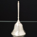 METAL PRATEADO, uma (1) sineta de mão, ornamentação cinzelada em elementos vegetalistas no padrão Império Otomano, badalo adaptado, medindo 13 cm altura, vide foto.